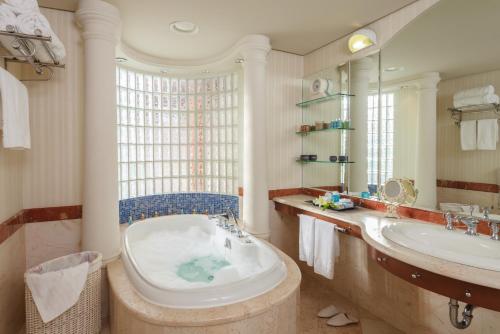 a bathroom with a tub and a sink at Herods Palace Hotels & Spa Eilat a Premium collection by Fattal Hotels in Eilat