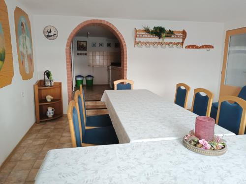 a dining room with two tables and blue chairs at Sklípek u Šťavíků Za Valama in Čejkovice