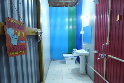 une salle de bain avec toilettes et une cabine de douche colorée dans l'établissement Happy Hippy Hub by Yatrimap, à Jāmb