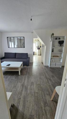 un salon avec un canapé bleu et une table dans l'établissement La Tanière Sedanaise 2 bedrooms parking wifi, à Sedan