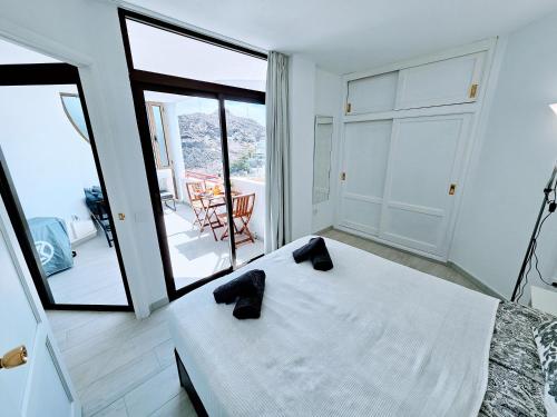a bedroom with a large white bed and a balcony at OCEAN VIEW - renovation 2025 in Playa del Cura