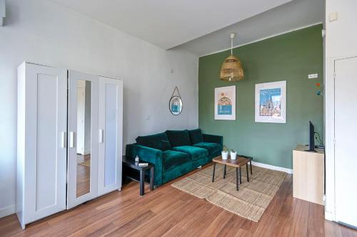 un salon avec un canapé vert et une table dans l'établissement Beautiful studio close to the beach, à Marseille