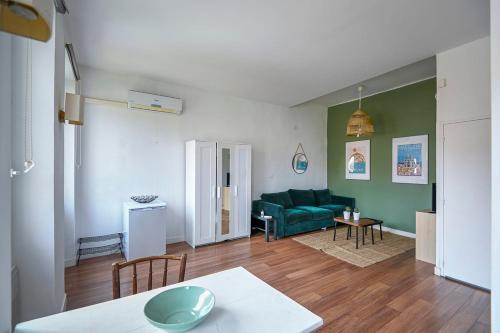 un salon avec un canapé vert et une table dans l'établissement Beautiful studio close to the beach, à Marseille
