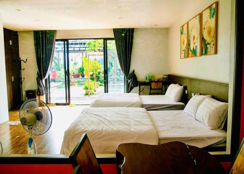 a hotel room with two beds and a fan at Trần Gia Homestay in Văn Chấn