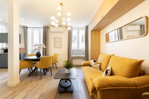 un salon avec un canapé jaune et une table dans l'établissement Pick A Flat's Apartments in Montmartre - Rue Gauthey, à Paris