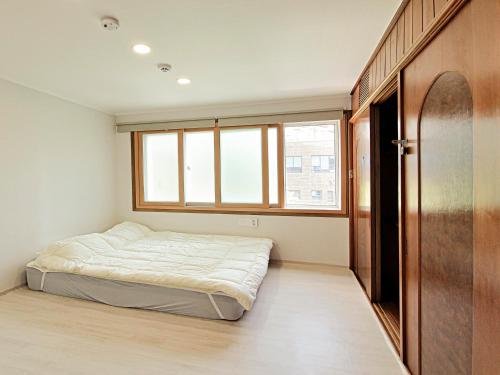 a bedroom with a bed and a window at A spacious and pleasant accommodation for up to 10 people, Haeundae station walking 6 minutes and beach walking 8 minutes in Busan