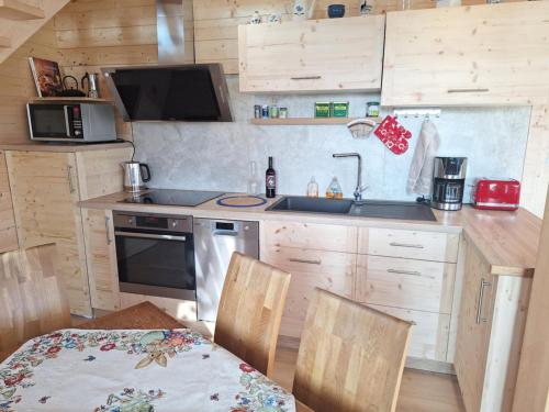 Il comprend une cuisine équipée d'un évier, d'une cuisinière et d'une table. dans l'établissement Atelier Scandinave, à Westhoffen