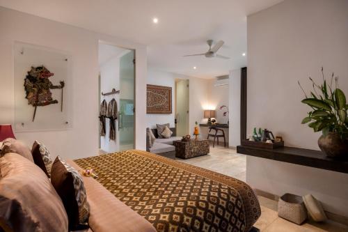 a bedroom with a bed and a living room at Kelapa Retreat & Spa in Pulukan