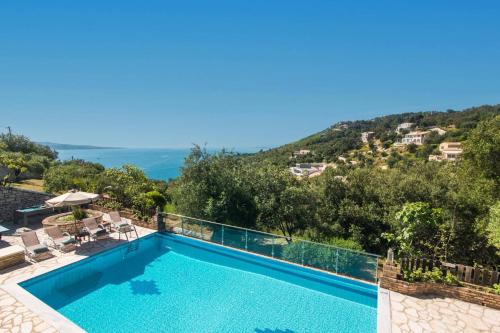 a villa with a swimming pool and a mountain at Villa Adonis by Villa Plus in Agnítsini