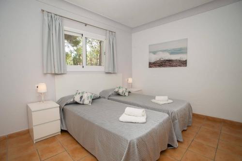 a bedroom with two beds with towels on them at Villa Alcudia Beach by Villa Plus in Port d'Alcudia