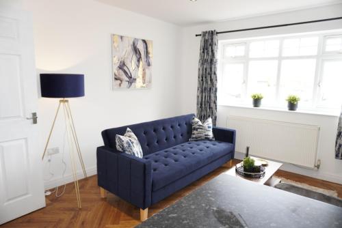 a living room with a blue couch and a window at St Marks Court Apartments in Anlaby