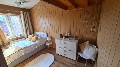 Un dormitorio con una cama y una cómoda y una ventana. en Apartament Tarasy, en Gdansk