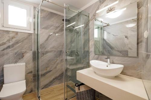 a bathroom with a sink and a glass shower at Villa Alena by Villa Plus in Kalami