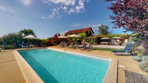 - une piscine avec des chaises et des parasols à côté d'une maison dans l'établissement Le Domaine des Fargues, à Sainte-Foy-de-Longas