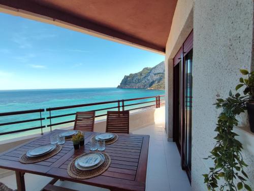 Una mesa en un balcón con vista al mar. en Apartamento Dúplex Aloha Calpe, primera línea de playa, en Calpe