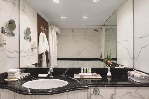 a bathroom with a sink and a large mirror at Ramada Plaza By Wyndham Palm Grove in Mumbai