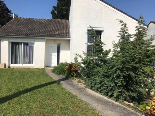 une maison blanche avec un arbre devant dans l'établissement Location MAISON LE MANS, à Rouillon