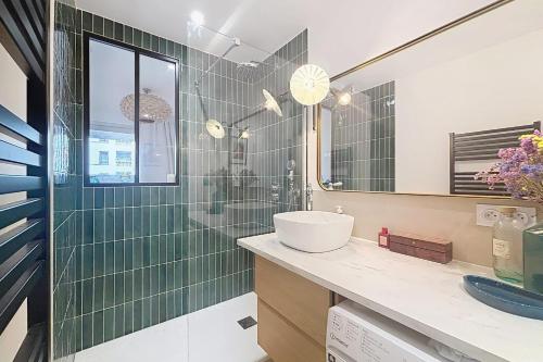 une salle de bain avec un lavabo et une douche en verre dans l'établissement Elegant apartment near Belleville & Jourdain, à Paris