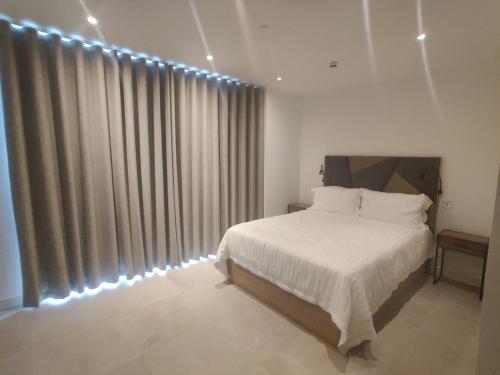 a bedroom with a white bed and a large window at Gibraltar Self-catering Studio Accommodation in Gibraltar