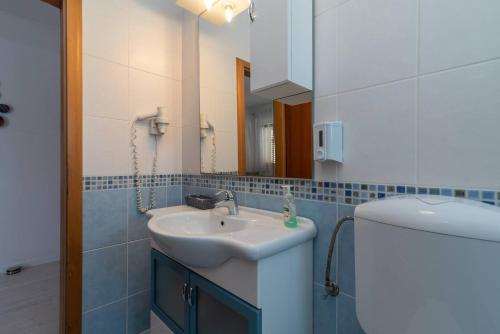 a bathroom with a sink and a mirror at Stylish triple room with balcony in Trogir