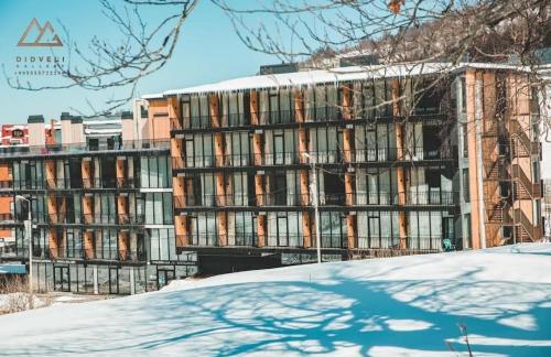 a large building with snow on the ground in front of it at Bakuriani - Didveli Gallery, B 203 in Bakuriani