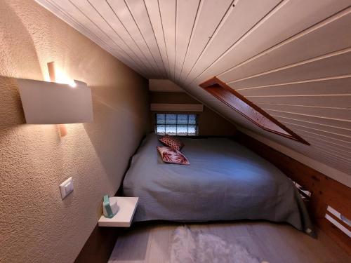 a small bedroom with a bed in a attic at Joli nid cosi à la montagne -Lécherette in Chateau-d'Oex