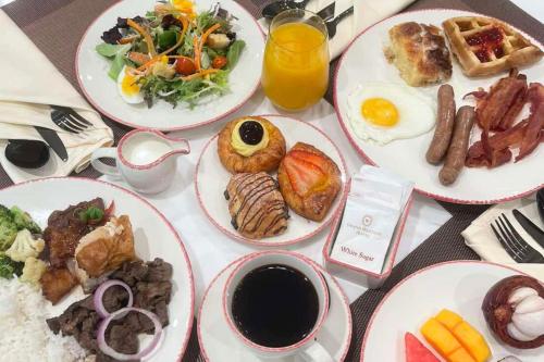 a table with plates of breakfast food on it at Grand Westside Manila Bay in Manila
