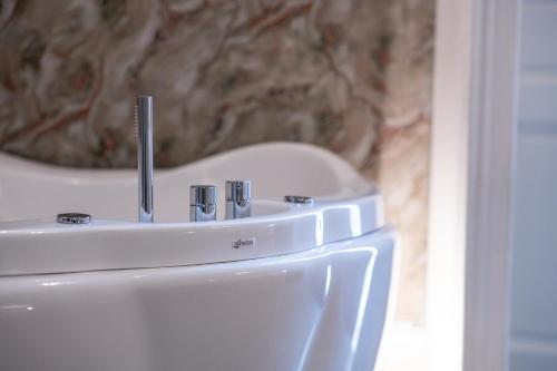 a white sink in a bathroom with a sink at Leone Camere D'autore - Rooftop Prince Centro Storico in Naples