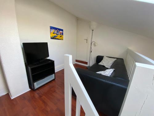 a living room with a couch and a tv at Vieux Boucau, Appartement 4 personnes, 2 chambres et Terrasse in Vieux-Boucau-les-Bains