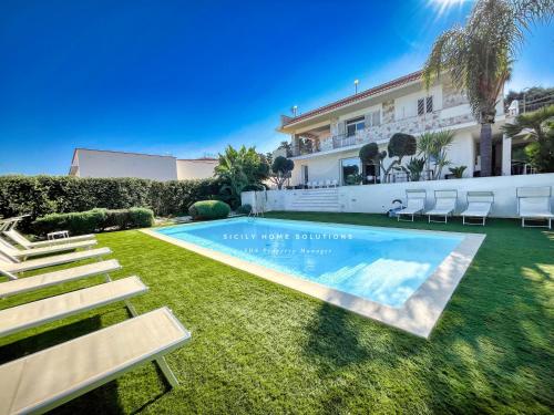 a swimming pool in the yard of a house at Oasi Elegante Piscina di Lusso - vista panoramica By Sicily Home Solutions in Alcamo