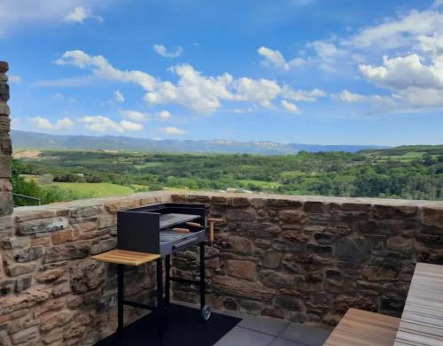 a room with a stone wall with a laptop on a table at Corral de l'esquirol in Basturs