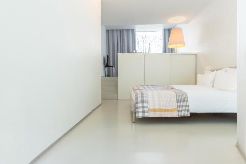a white bedroom with a bed and a window at Greulich Design & Boutique Hotel in Zürich