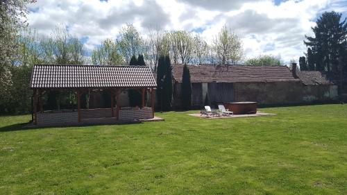 a gazebo with two chairs in a yard at Almafás Jakuzzis Vendégház Őrség in Kerkakutas