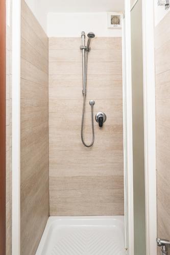 a shower in a bathroom with wooden walls at Affittacamere - L'ancora in Stintino