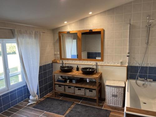 une salle de bain avec deux lavabos et un miroir dans l'établissement Maison avec piscine 4 chambres 8 couchages, à Agris