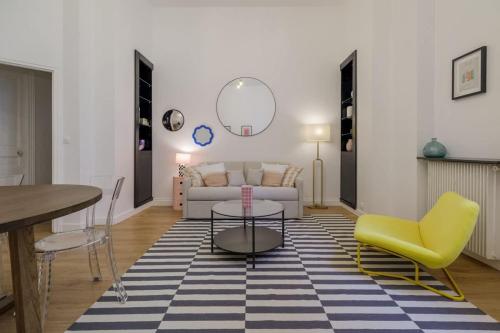 un salon avec un canapé, une table et des chaises dans l'établissement Perretti - Spacious Flat 2BDR Paris Neuilly, à Neuilly-sur-Seine