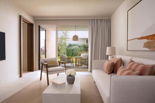 a living room with a white couch and a table at Fairmont La Hacienda Costa del Sol in Alcaidesa