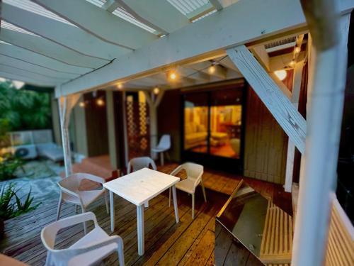 a porch with a table and chairs on a house at 沖縄随一の絶景! 静かなヴィラでゆっくりと最高の旅を! Villa VIEW in Nanjo