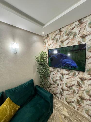 a living room with a couch and a tv on a wall at Luxury haven with pool in Agadir