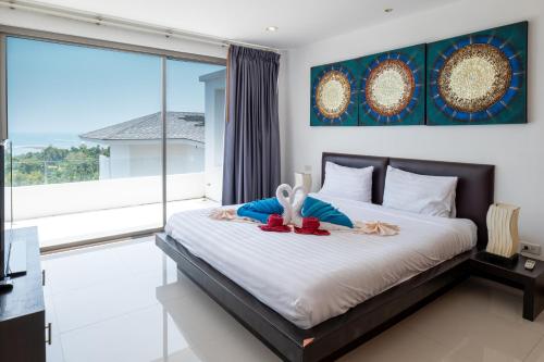 a bedroom with a bed with a large window at Tropical Sea View Residence in Lamai