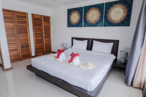 a bedroom with a bed with two stuffed animals on it at Tropical Sea View Residence in Lamai