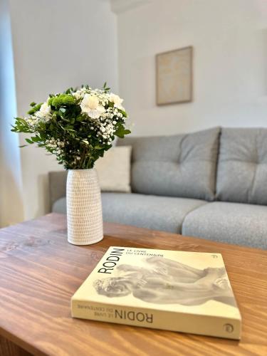 un livre assis sur une table avec un vase de fleurs dans l'établissement Chic flat with elevator 4 guests Bourse de Paris, à Paris