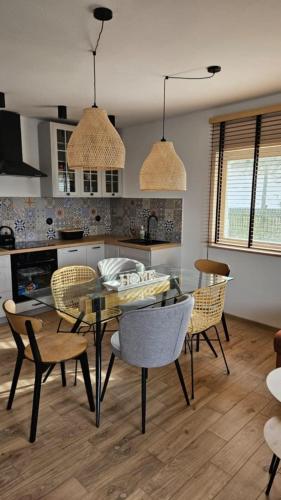 a kitchen and dining room with a table and chairs at Dom letniskowy do wynajęcia z własną Przystanią nad rzeką Narew - linia brzegowa in Dzbenin