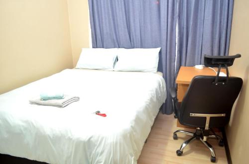a bedroom with a bed and a desk and a chair at Oasis Home in Midrand