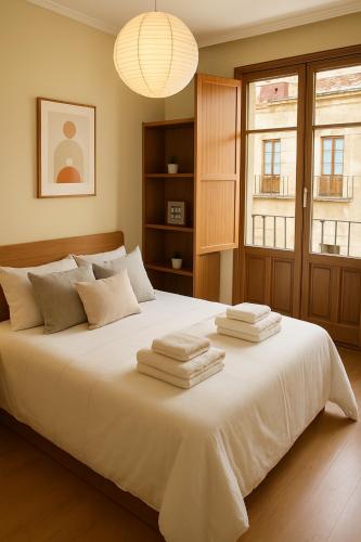 サラマンカにあるSan Justo Suitesのタオルが敷かれた大きな白いベッドのある寝室
