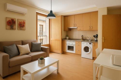 サラマンカにあるSan Justo Suitesのソファとキッチンのあるリビングルーム