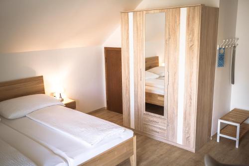 a bedroom with a bed and a large wooden cabinet at Haus Dietrich am Red Bull Ring in Spielberg