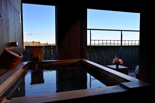 a house with a swimming pool on a balcony at Laforet Shuzenji Sanshisuimei in Izu
