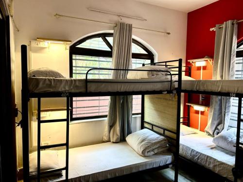 two bunk beds in a room with a window at Hostel Lifespace- Tailor made for working professionals- Luxurious Twin Bungalow with CoWork- only 3 and 4 share Rooms in Pune