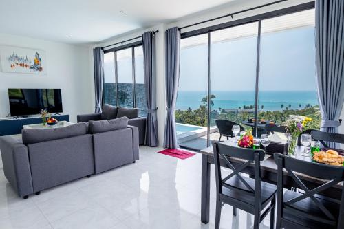 a living room with a couch and a table and chairs at Tropical Sea View Residence in Lamai
